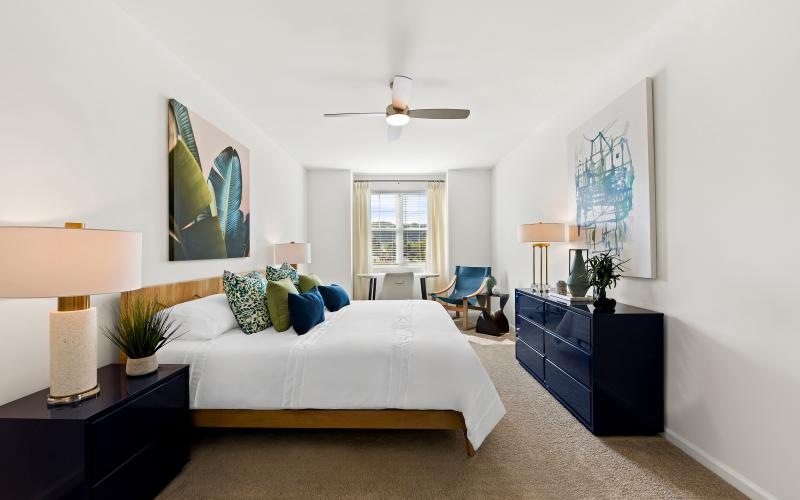 a bedroom with a bed and a fan